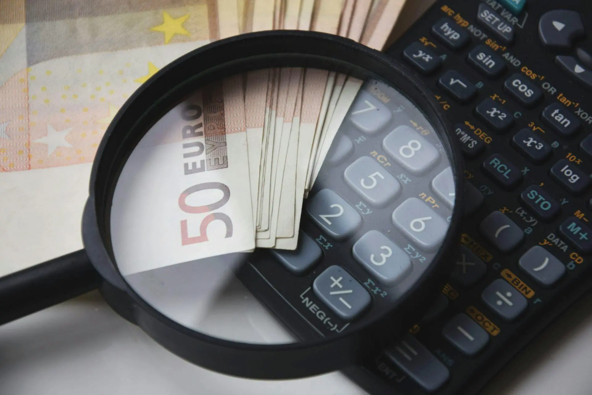 Lente di ingrandimento con denaro e calcolatrice